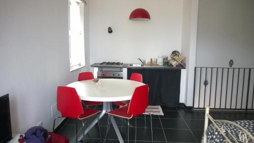 eine Küche mit einem weißen Tisch und roten Stühlen in der Unterkunft Casa Ronco Scalzo in Palazzolo Acreide