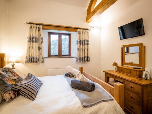 a bedroom with a bed with a mirror and a dresser at Grayrigg Foot Stable in Grayrigg