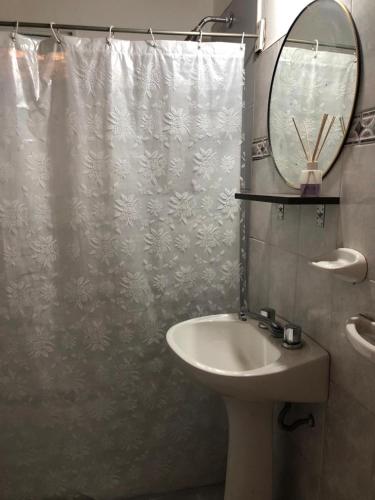 uma casa de banho com um lavatório e uma cortina de chuveiro em Posada El Cerrito em São Rafael