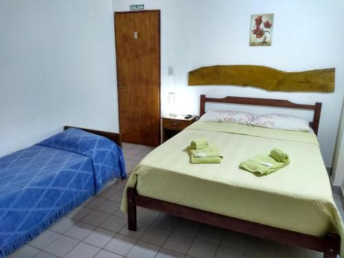 een slaapkamer met een bed met twee handdoeken erop bij Hosteria Las Piedras in Puerto Iguazú