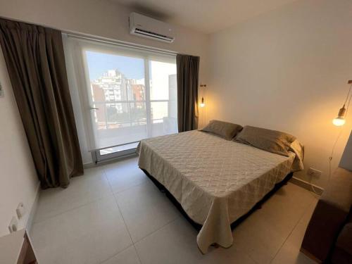 1 dormitorio con cama y ventana grande en Departamento a estrenar con Pileta para 4- Río 5 en Buenos Aires