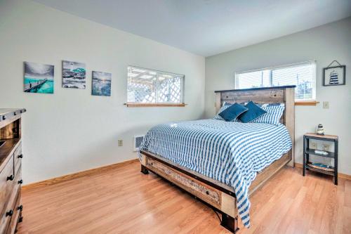 a bedroom with a bed with a blue and white comforter at Fire Pit and Bay Views North Bend Home! in North Bend
