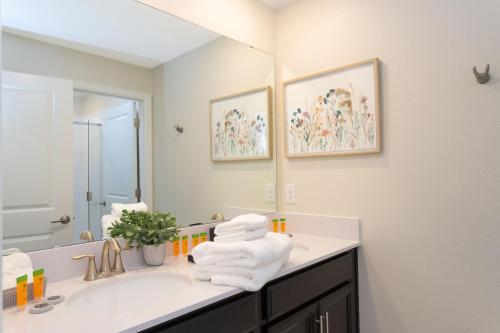 a bathroom with a sink with towels on the counter at Gorgeous 4 Bd w/ Pool at Champions Gate Resort 1020 in Orlando