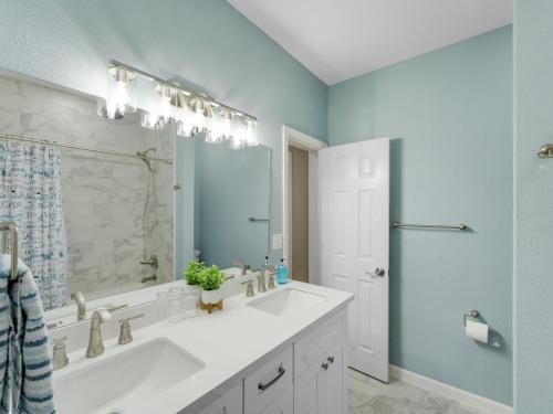 een badkamer met 2 wastafels en een grote spiegel bij Galveston Escapes - Walk to Beach and Restaurants in Galveston
