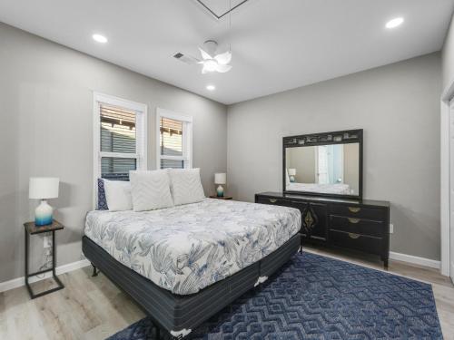 Schlafzimmer mit einem Bett, einer Kommode und einem Spiegel in der Unterkunft Galveston Escapes - Walk to Beach and Restaurants in Galveston