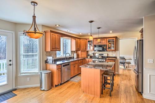 a kitchen with wooden cabinets and a large island at Pet-Friendly Beacon Area Vacation Rental 6 Acres in Lagrangeville