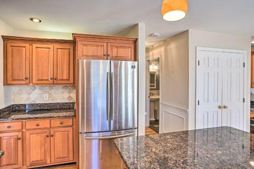 a kitchen with wooden cabinets and a stainless steel refrigerator at Pet-Friendly Beacon Area Vacation Rental 6 Acres in Lagrangeville
