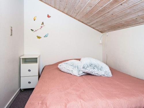 a bedroom with a pink bed with two pillows at Holiday home Sydals LXXVII in Sønderby