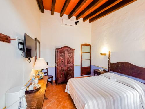 a bedroom with a bed and a television in it at Meson del Alferez Xalapa in Xalapa