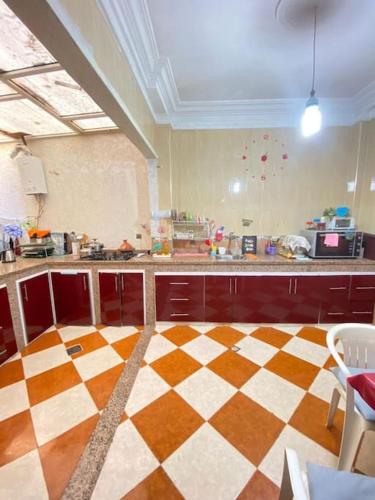 a large kitchen with a checkered floor at Grande maison Calme in Meknès