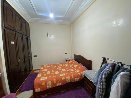 ein Schlafzimmer mit einem Bett mit einer orangefarbenen Bettdecke in der Unterkunft Grande maison Calme in Meknès