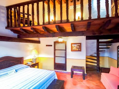 a bedroom with a bed and a wooden staircase at Meson del Alferez Xalapa in Xalapa