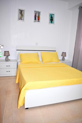 a bedroom with a bed with yellow sheets and two lamps at Taninho in Santa Maria