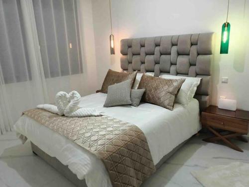 a large bed with a large headboard in a bedroom at Neuf et raffiné, centre ville Rabat in Rabat