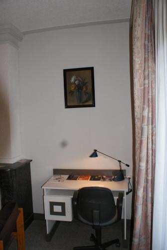 un bureau avec une chaise dans une pièce avec une photo dans l'établissement Hotel Domstad, à Utrecht