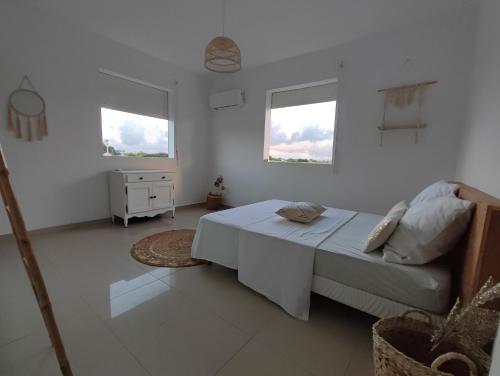 a white bedroom with a bed and a couch at Kukumi's House in Sainte-Anne
