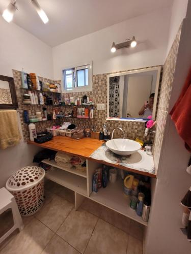 baño con lavabo y encimera con espejo en Departamento Eduardo en San Bernardo