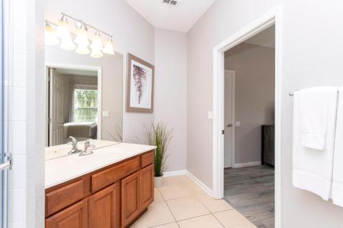 bagno con lavandino e specchio di Magnificent 2 Bedroom Apartment Vista Cay Resort 107 a Orlando