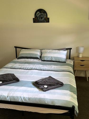 1 dormitorio con 1 cama con toallas en Retreat at Raymond, en Raymond Island