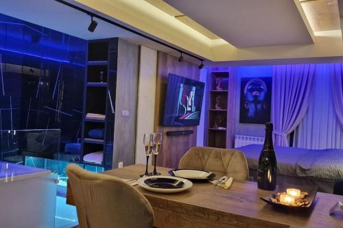 a dining room with a table with a bottle of wine at Romantic & Jacuzzi in Skopje