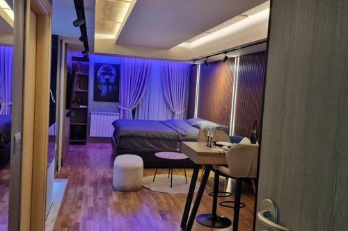 a bedroom with a bed and a table in it at Romantic & Jacuzzi in Skopje