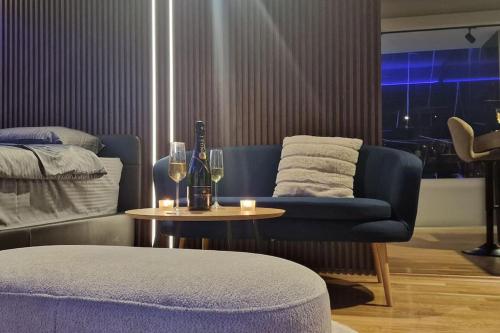 a living room with a couch and a table with wine glasses at Romantic & Jacuzzi in Skopje