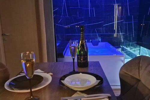 a table with a bottle of wine and two glasses at Romantic & Jacuzzi in Skopje