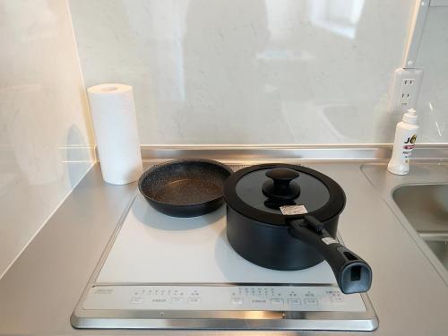 a pot on a stove with a pan on it at PRISM Inn Komagata Asakusa in Tokyo