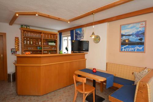a bar in a restaurant with a counter and a table at Haus Irmgard by Châtel Reizen in Tux