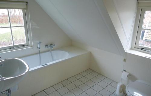 een witte badkamer met een wastafel en een bad bij Buitengoed Het Lageveld - 55 in Hoge-Hexel