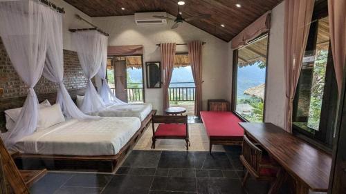 1 Schlafzimmer mit 2 Betten in einem Zimmer mit Fenstern in der Unterkunft Amigo Pu Luong in Làng Bang
