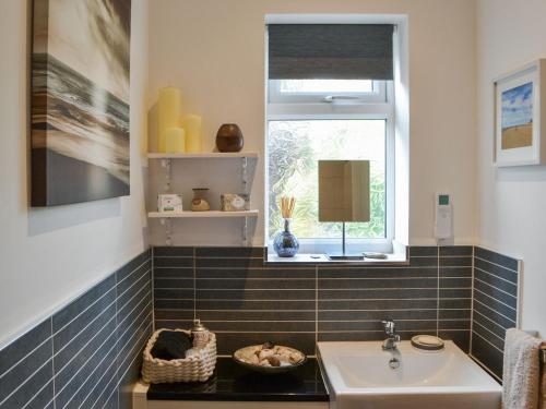 a bathroom with a sink and a window at Quarrymans Cottage in Belford