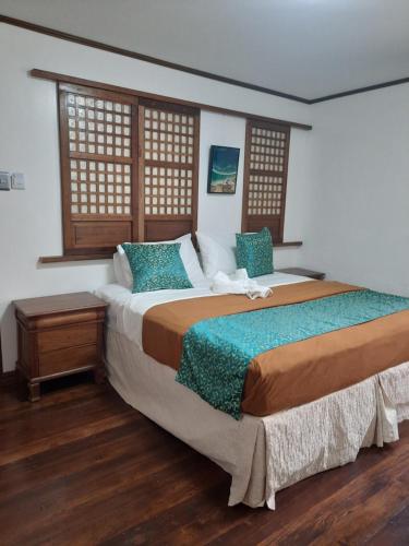 a bedroom with a large bed and two windows at BALÉ in Malabañas
