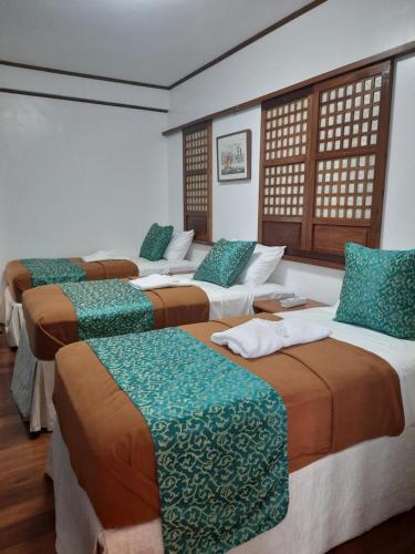 eine Gruppe von 4 Betten in einem Zimmer in der Unterkunft BALÉ in Malabañas