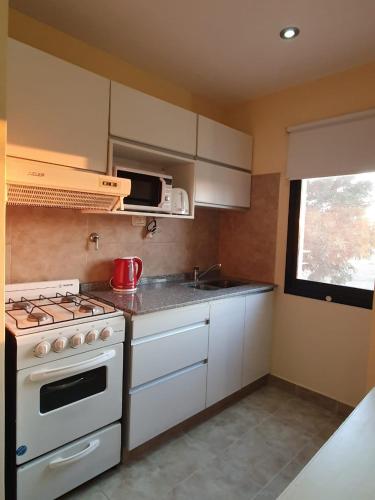 a kitchen with a white stove and a microwave at Arenas de Colón in Colón