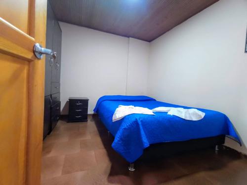 a bedroom with a blue bed in a room at Apartamentos CasaMJ Tunja Confort y Parqueadero in Tunja