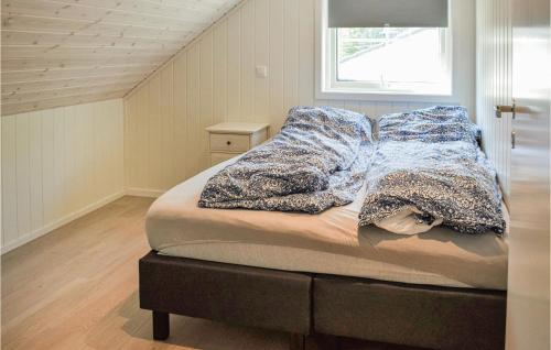 a bedroom with a bed with blankets and a window at Five-Bedroom Holiday Home In Ana-Sira in Åna-Sira