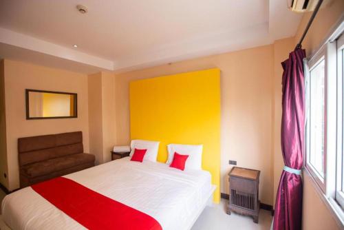 a bedroom with a bed with a red and yellow wall at The Main Event in Pattaya South