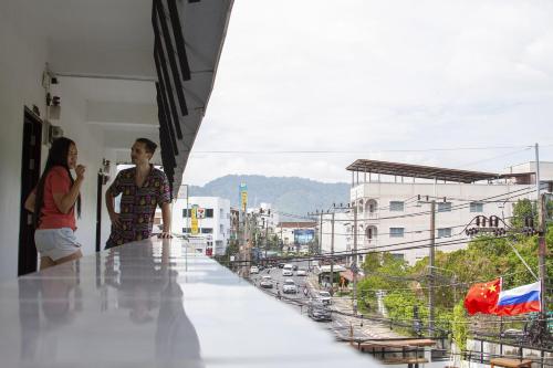 two people standing on a balcony looking at a city at The Auto Place in Ban Sam Kong
