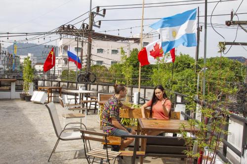 a man and a woman sitting at a table with flags at The Auto Place in Ban Sam Kong