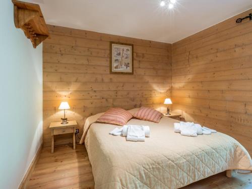 una camera da letto con pareti in legno e un letto con asciugamani di Appartement Saint-Martin-de-Belleville, 3 pièces, 6 personnes - FR-1-461-30 a Saint-Martin-de-Belleville