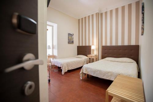 a hotel room with two beds and a window at V Dinastia in Lisbon