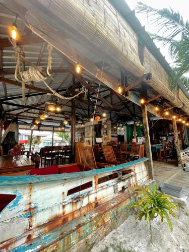 a building with a table and chairs and a roof at Rock and Wreck Dive Resort in Tanjungbinga