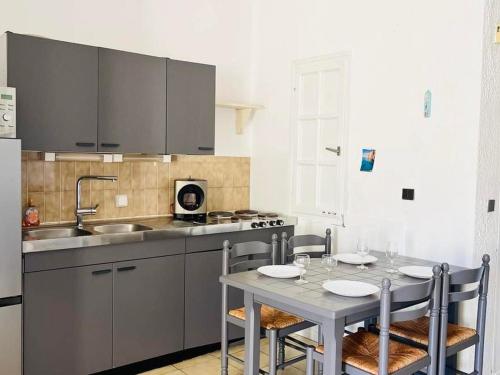 cocina con mesa y fregadero en Appartement Lumio, 1 pièce, 2 personnes - FR-1-63-322, en Lumio