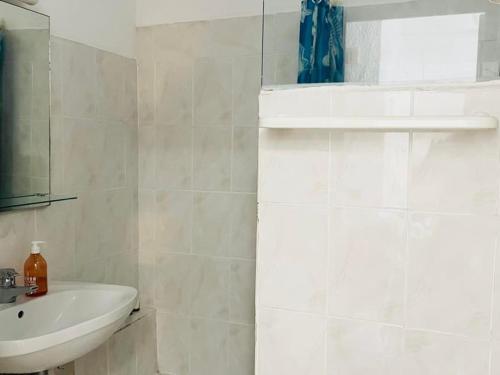 Baño blanco con lavabo y espejo en Appartement Lumio, 1 pièce, 2 personnes - FR-1-63-322, en Lumio