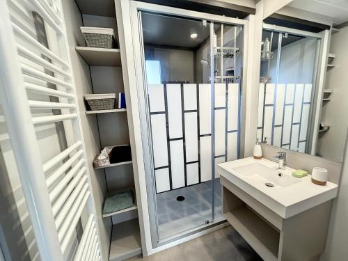 ein Bad mit einer Dusche, einem Waschbecken und einem Spiegel in der Unterkunft Chalet Jullouville, 4 pièces, 7 personnes - FR-1-361-463 in Jullouville-les-Pins