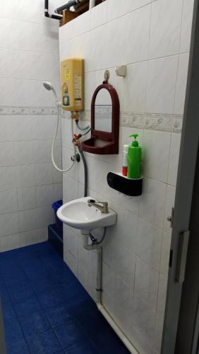 a bathroom with a sink and a mirror on the wall at Garfield Homestay in Batu Pahat