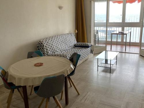 un salon avec une table et un canapé dans l'établissement Appartement 1 Chambre Face aux Îles d'Or avec Parking, Port d'Hyères - FR-1-335-182, à Hyères