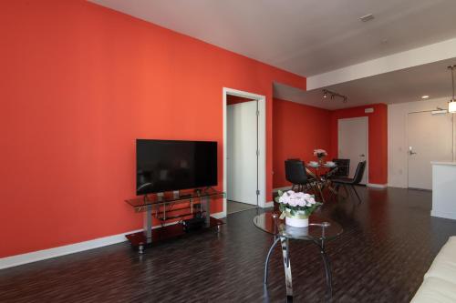 a living room with red walls and a flat screen tv at Modern Apartment Rentals in Los Angeles