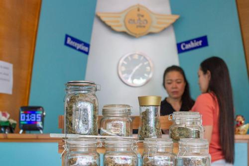 Un par de personas sentadas en un mostrador con tarros en The Auto Place, en Ban Sam Kong